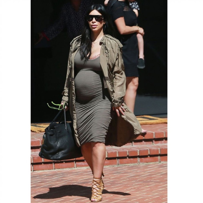 كيم في حملها الأول في فستان أسود وصندل أبيض