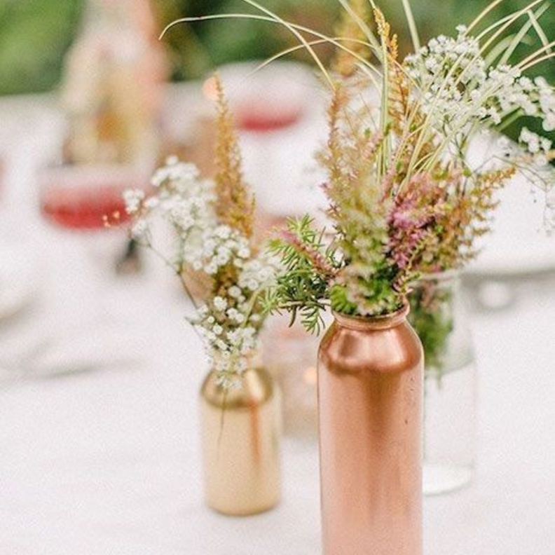 تزيين طاولة الزفاف بالقناني البرونزية.