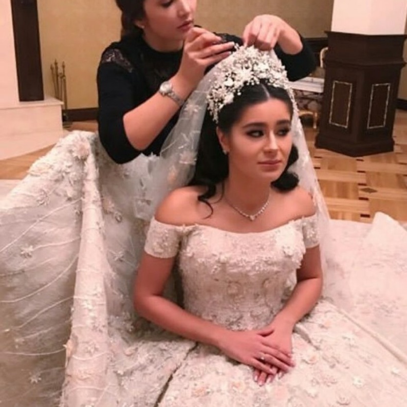 نسقت العروس الروسية طرحة طويلة فخمة مع فستان الزفاف