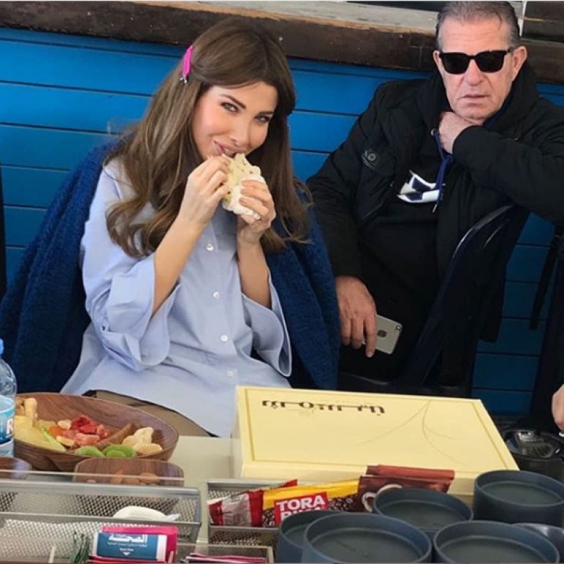 نانسي عجرم تستمتع بتناول المنقوشة في لقطة عفوية اثناء تصويرها الفيديو كليب الجديد