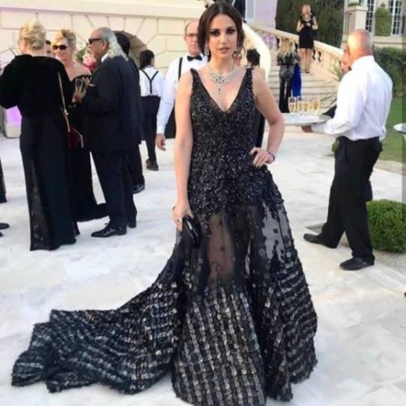  تميّز الفستان بياقته المنسدلة عند الاكتاف والكمّ الواحد الطويل وقصة الداربيه عند الصدر والارداف