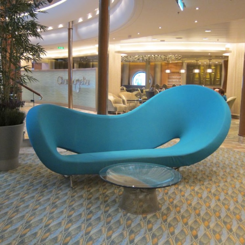 أريكة غير تقليدية بألوان الزهر ضمن غرفة معيشة كلاسيكية ومودرن