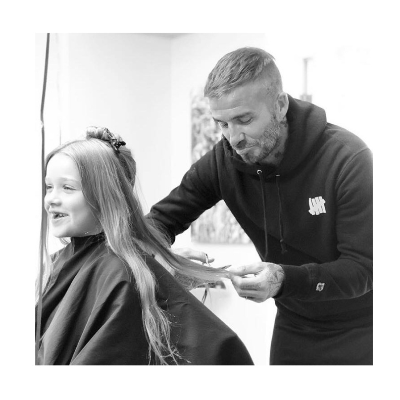 يبدو ديفيد بيكهام متأثرا وهو يقص الخصلات الطويلة لشعر ابنته هاربر