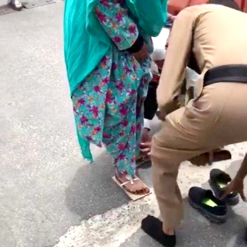 الحاج يساعد الحاجة المسنة على تثبيت الحذاء الذي صنعته من الورق المقوى