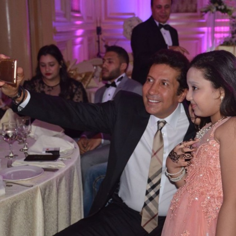 هاني رمزي يلتقط صورة مع طفلة في حفل الزفاف