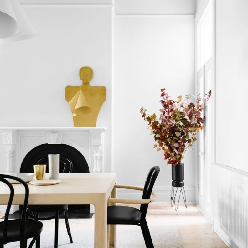 ثريات رائعة باللون الذهبي تبرز جمال غرفة الطعام بلونها الأبيض