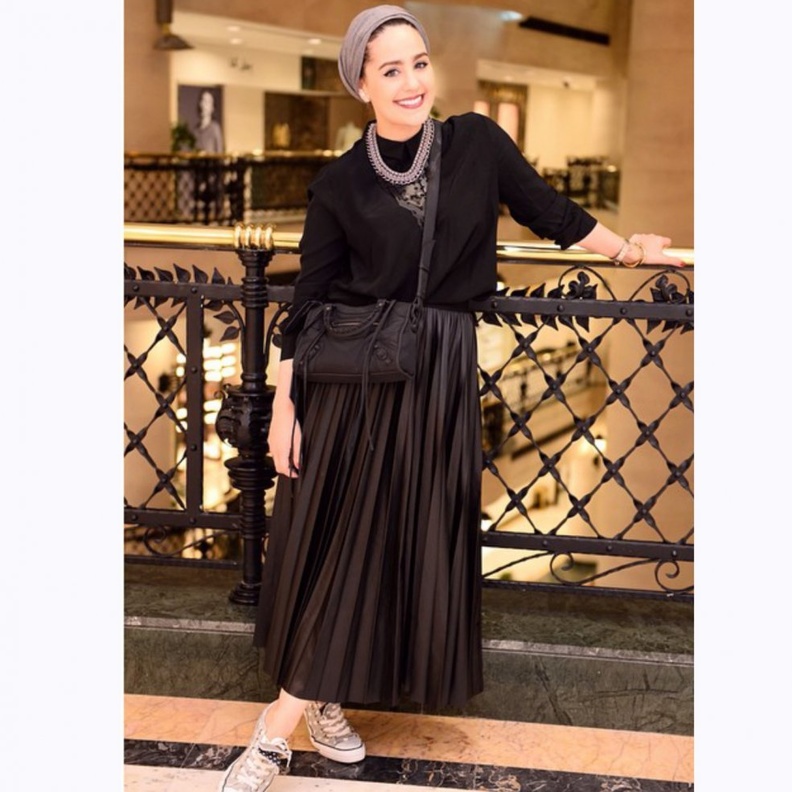 السويت شيرت السوداء مع التنورة البليسيه الجلدية بأسلوب دينا طوكيو.