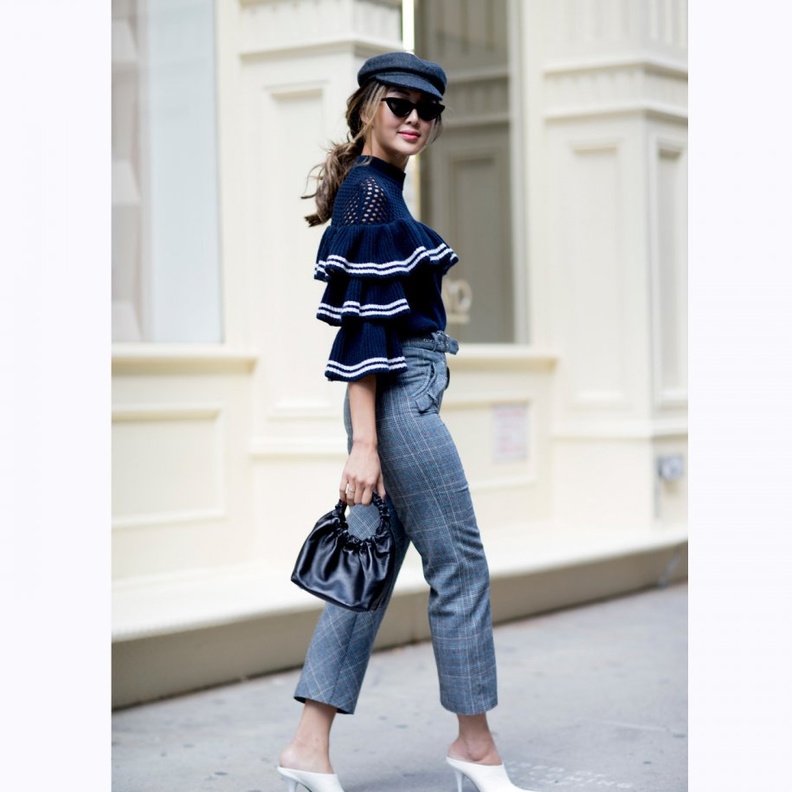 اختاري توب أنيقة باللون الأسود مزينة بالكشكش مع بنطلون الجينز.