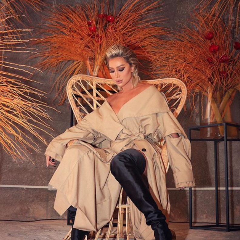 اطلالة عصرية وجذابة لمايا دياب بالترينشكوت بلون البيج مع الحذاء الشتوي العالي باللون الأسود