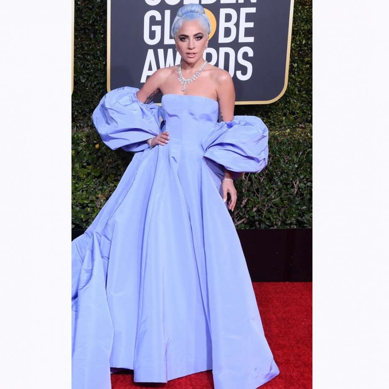 تميّز فستان لايدي غاغا بأكمامه الضخمة والطرحة الطويلة التي غطت السجادة الحمراء