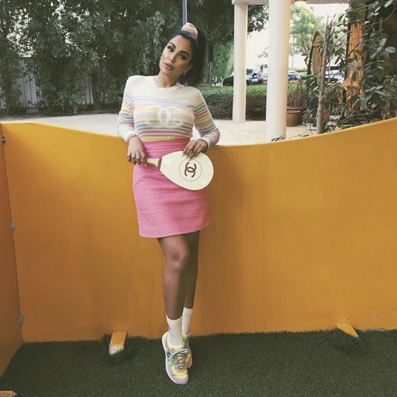 إطلالة بتنورة مزدانة بطبعة الكاروه وجوارب طويلة فوق الركبة