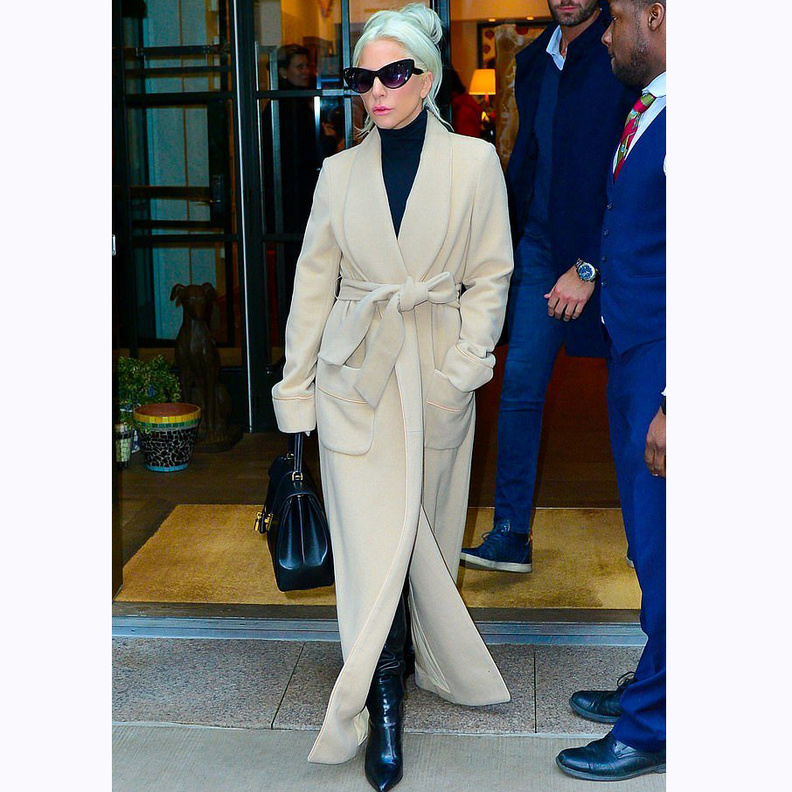 تألّقت غاغا بمعطف طويل وأنيق باللون البيج، معقود عند الخصر بحزام من القماش نفسه
