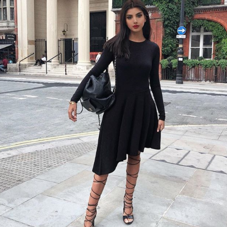 اختارت علا فرحات فستان ميدي باللون الأسود نسقته مع صندل كعب عالي مزين بالربطات