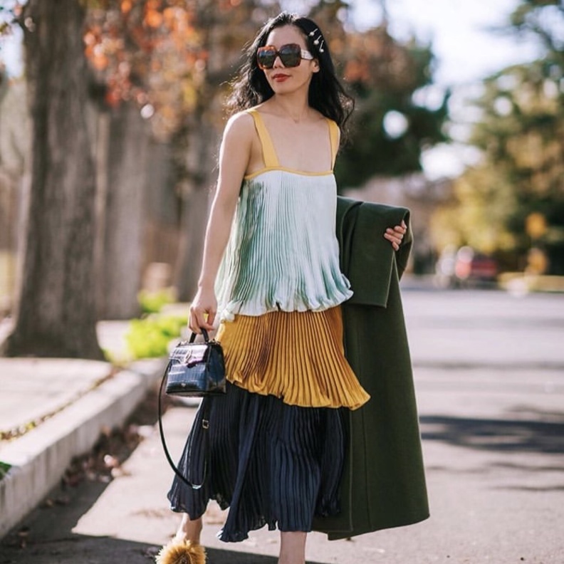 إطلالة خارجة عن المألوف بتنسيق قميص وتنورة مفصلة بموضة الكسرات