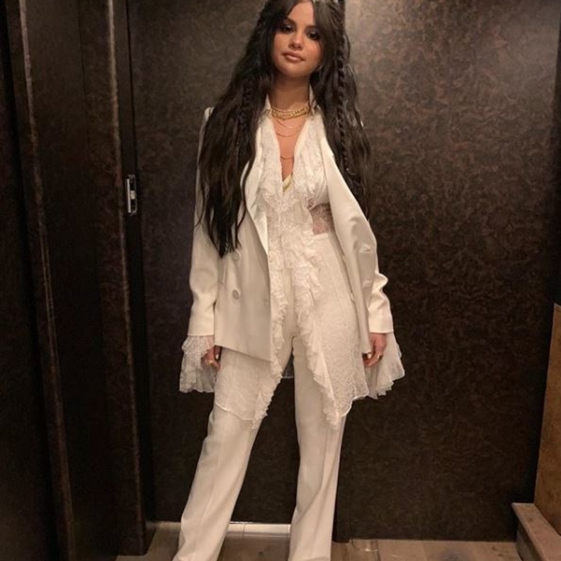 إختارت جيجي سترة من دون أكمام بلون بيج داكن نسّقتها مع سروال flare pants، وحذاء أسود