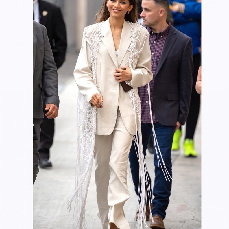  إطلالة عصرية ببدلة بيضاء مع سترة من الشبك والشراريب الطويلة