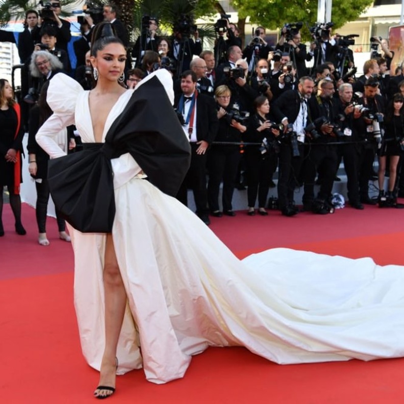  جمالDeepika Padukone بالفستان الأبيض الفضفاض مع العقدة السوداء البارزة من الأمام مع الأكتاف الجامدة