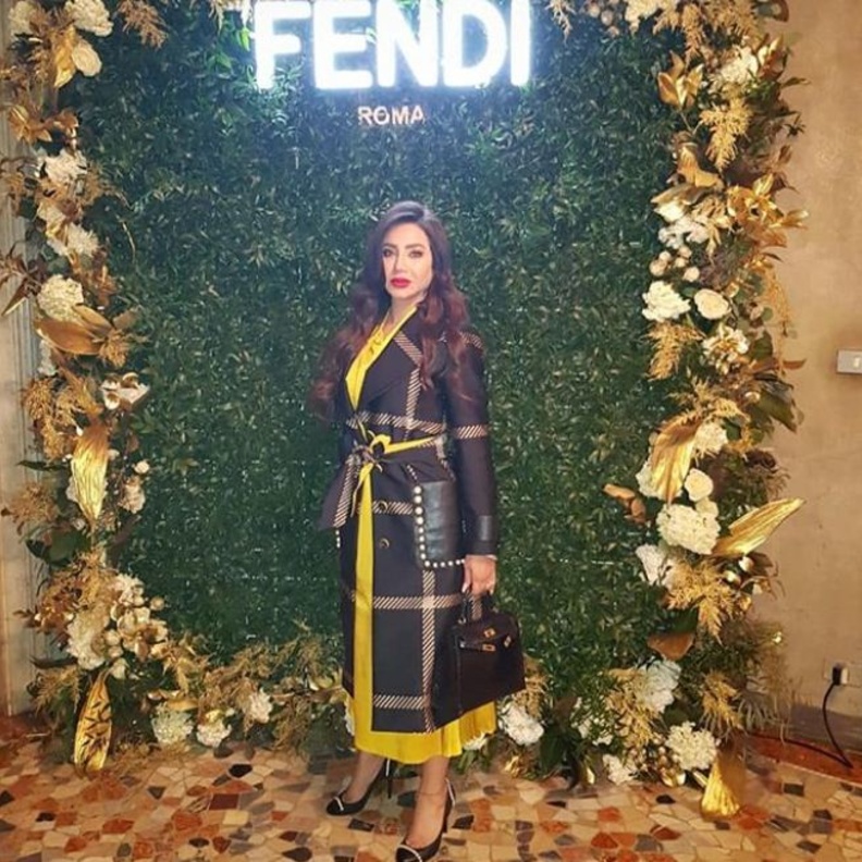 إختارت معطفاً طويلاً من Fendi نفسها نسّقته مع فستان ميدي أصفر