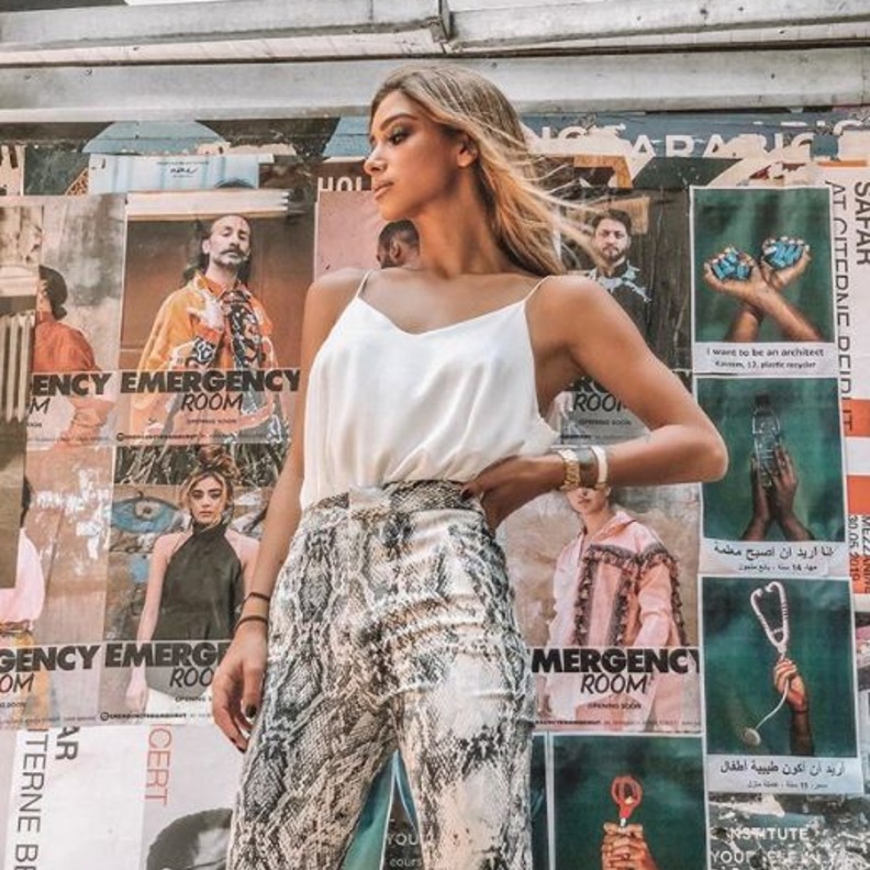 إختارت البلايزر الكلاسيكية باللون الزهري الفاتح وبقصة واسعة ونسقتها مع الدينيم الممزق