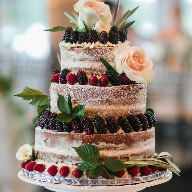 كعكات الزفاف البيضاء متعددة الطبقات والمزينة بزهور ملونة جميلة