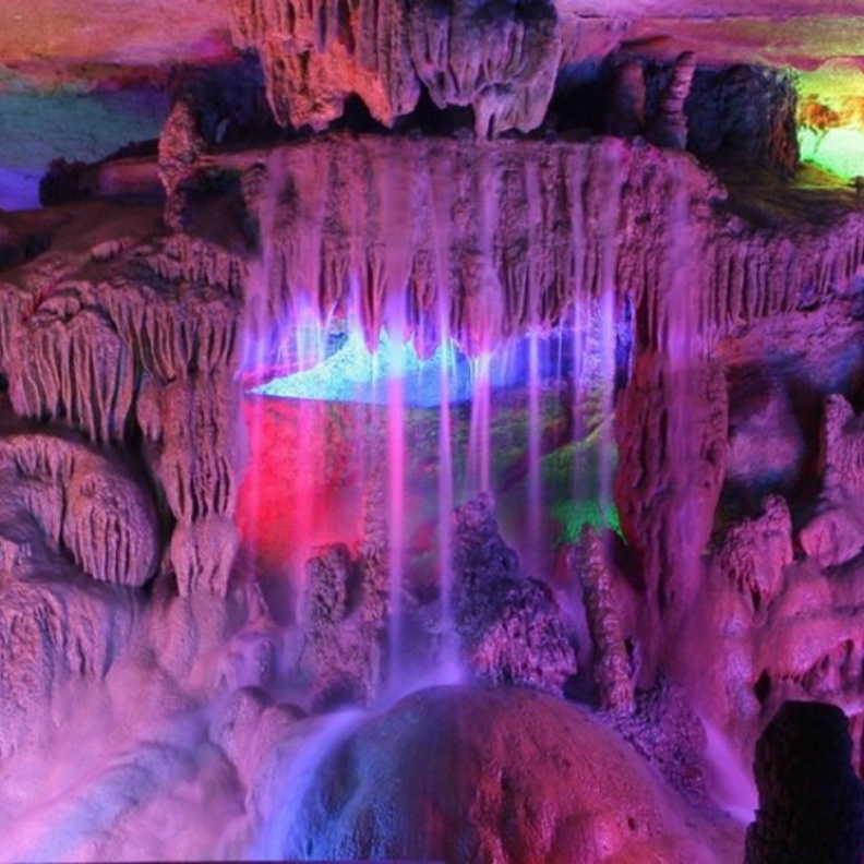 الكهف مضاء من الداخل بإضاءة نيون متعددة الألوان من صنع الإنسان لزيادة وضوح الرؤية في داخل الكهف