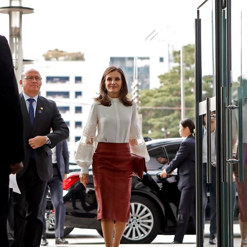 إختارت قميصاً أبيض نسّقت معه تنورة ميدي من قماش الجلد الأحمر