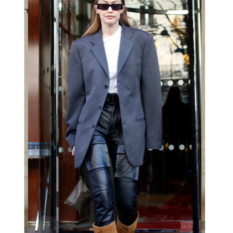  اطلالة جيجي حديد بموضة البنطلون الجلدي مع البلايزر الرمادية الطويلة