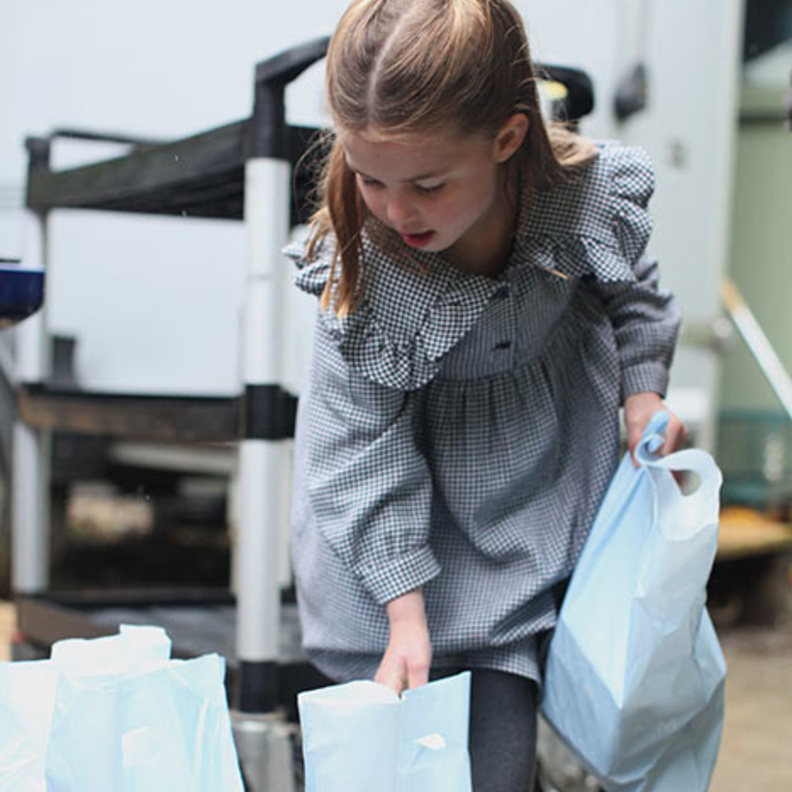  تظهر الصور شارلوت وهي تساعد في توضيب وتسليم رزمات من الطعام لأشخاص كبار في السن