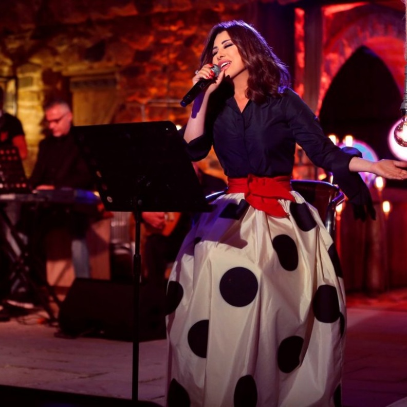 حددت نجوة خصرها بحزام أحمر