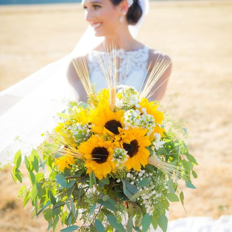 باقة زهور للعروس بدرجات لون أشعة الشمس تستخدم فيها زهور الشمس