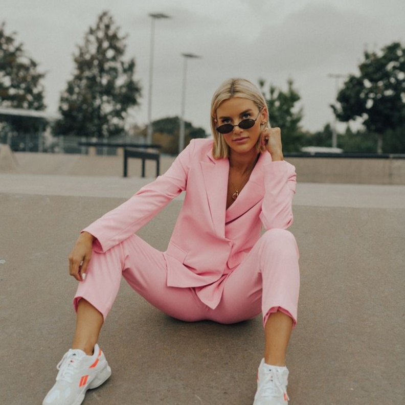 طريقة شبابية وعصرية بتنسيق البدلة باللون الزهري الأنثوي مع الحذاء الرياضي الأبيض