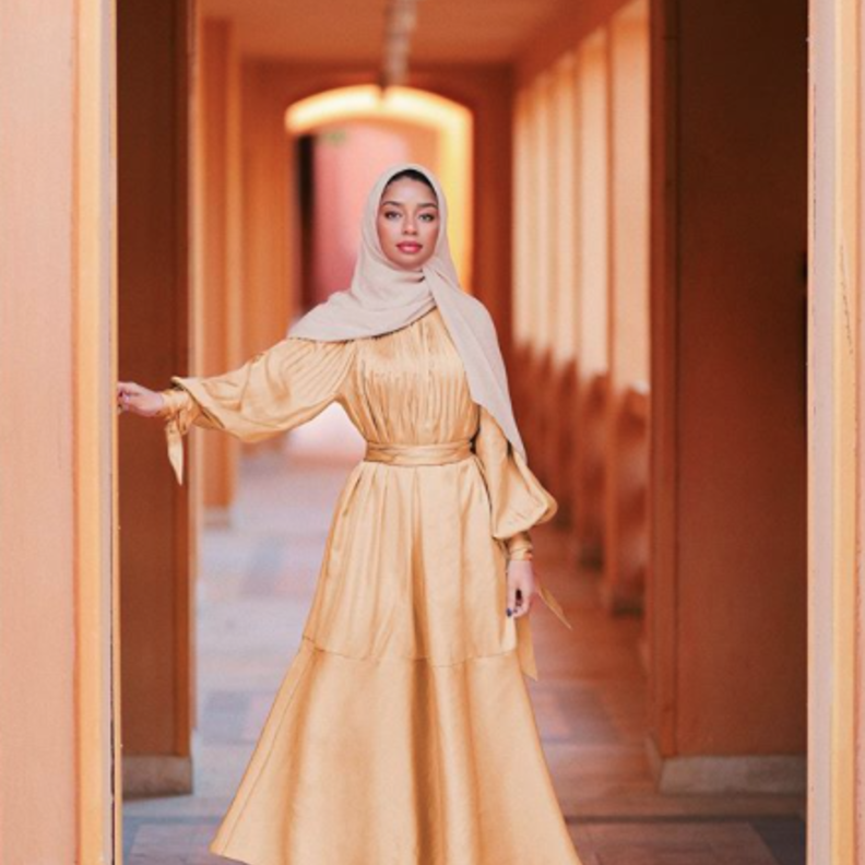  صفيّة غودسون باطلالة بسيطة وناعمة بفستان ميدي باللون الأصفر مع الصندل البيج الفاتح