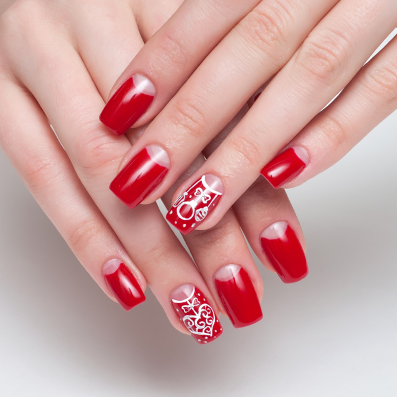 مناكير اللون الاحمر مع نقوش بسيطة من اللون الابيض ليوم المراة الاماراتية