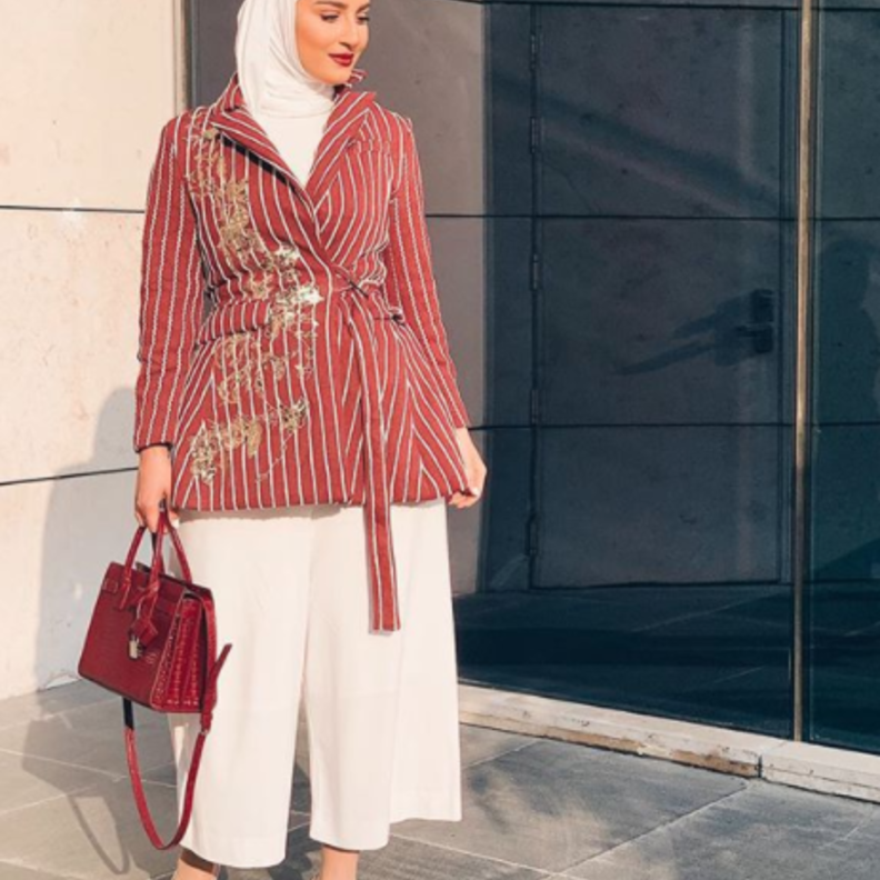 نسقت دلال الدوب البنطلون الأبيض مع بليزر مقلم