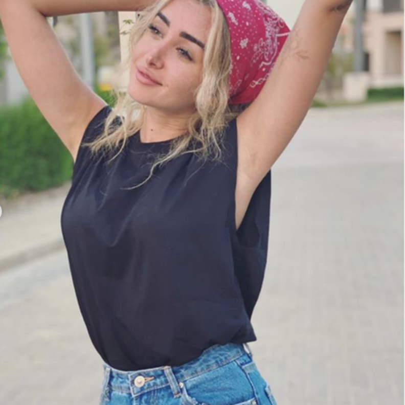 التوب الأسود بالقصة العصرية الرائجة نسّقته هنا مع جينز وباندانا الشعر الشبابية