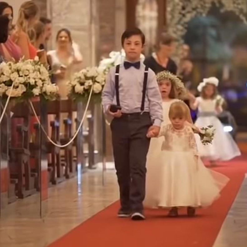 الاطفال متجهين نحو العروسين يتقدمهم أكبرهم و هو يحمل خاتم الزواج