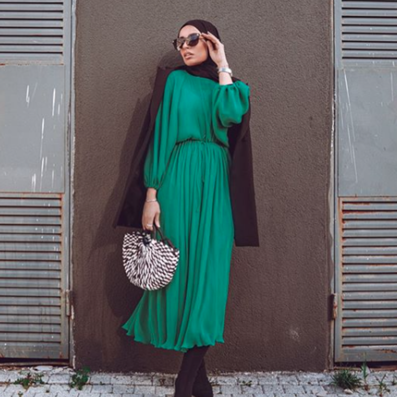 الأخضر الجذاب باطلالة شبابية بسيطة بالفستان الميدي مع الحذاء الشتوي العالي باللون الأسود والحقيبة باللونين الأبيض والأسود