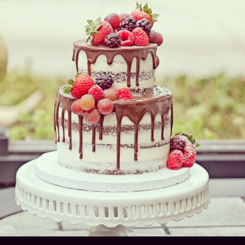  كيك زفاف مزينة الفراولة والتوت الأحمر ويغطيها صوص الشيكولاتة