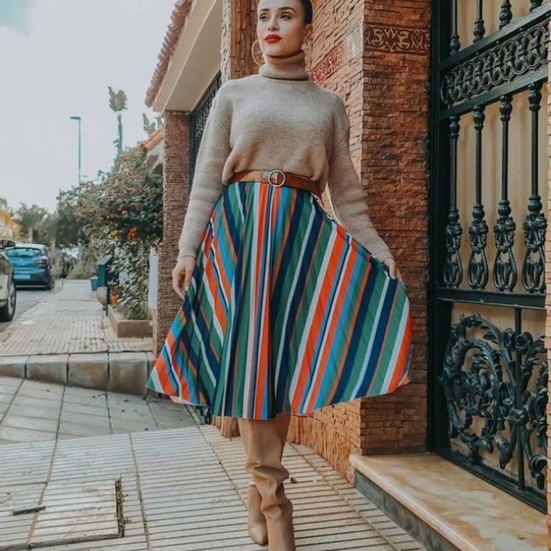  نسّقت مع الكنزة ذات الياقة العالية التنورة الميدي الملوّنة