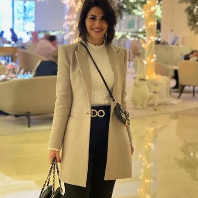 إختاري البنطلون الأسود مع التوب الأبيض بالياقة العالية وأكملي اللوك بمعطف أنيق