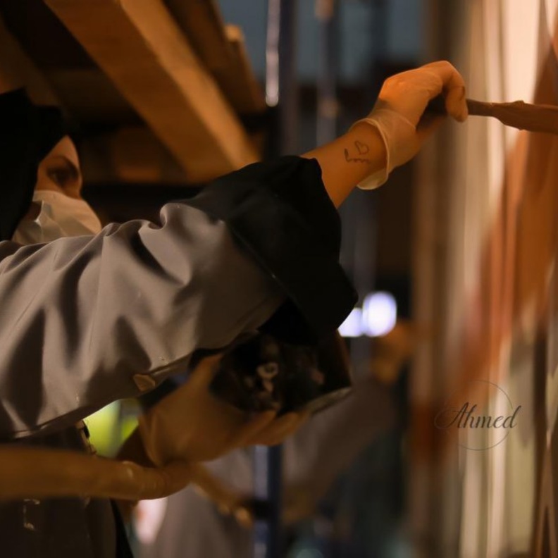  15 رساما ورسامة يشاركون في رسم جدارية تجميلية بجسر حي العوالي بالعاصمة المقدسة