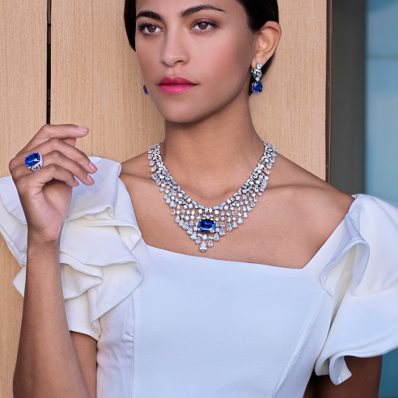 قلادة فاخرة من البلاتين والألماس يتوسطها حجر بقصة الوسادة من الياقوت الأزرق بقصة الوسادة. أقراط فاخرة من الذهب الأبيض والألماس تنتهي بحجرين من الياقوت الأزرق بقصة الوسادة. خاتم فاخر من البلاتين والألماس يتوسطه حجر بقصة الوسادة من الياقوت الأزرق. جميعها من دار "بولغري" Bvlgari للمجوهرات الفاخرة.