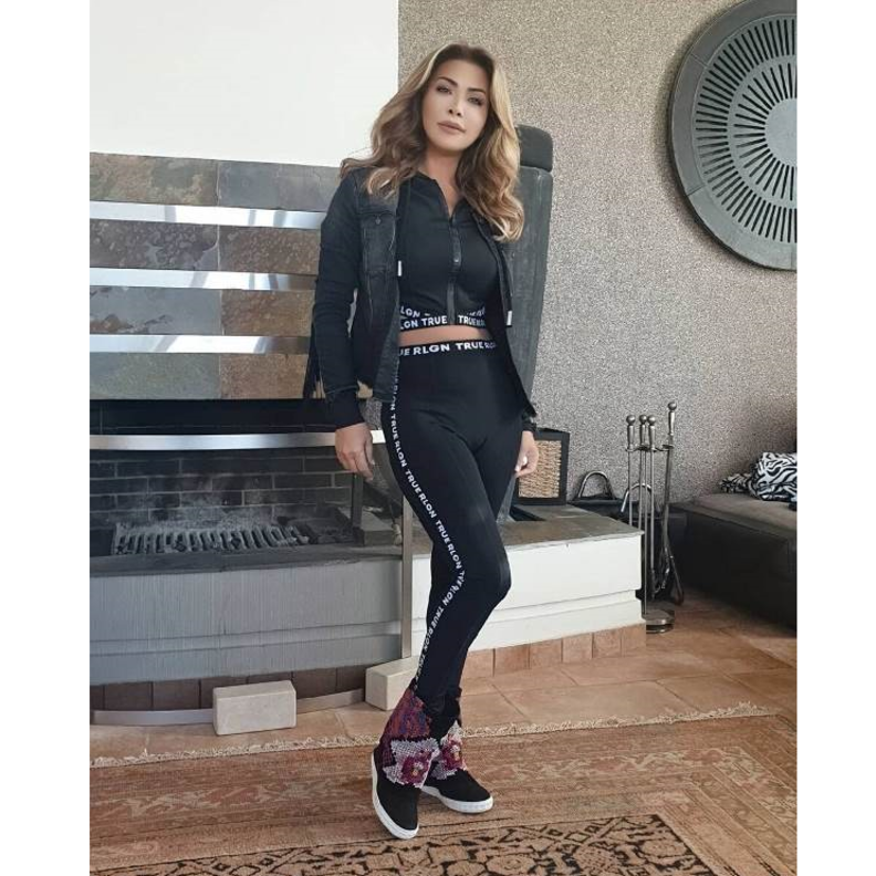 أطلت البدلة السوداء والتي تألفت من كروب توب وبنطلون ضيّق مزّين بالكتابات باللون الأبيض