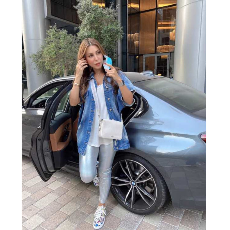 نسّقت الجاكيت الدنيم الأوفر سايز مع التيشيرت البيضاء الواسعة والبنطلون الفضيّ