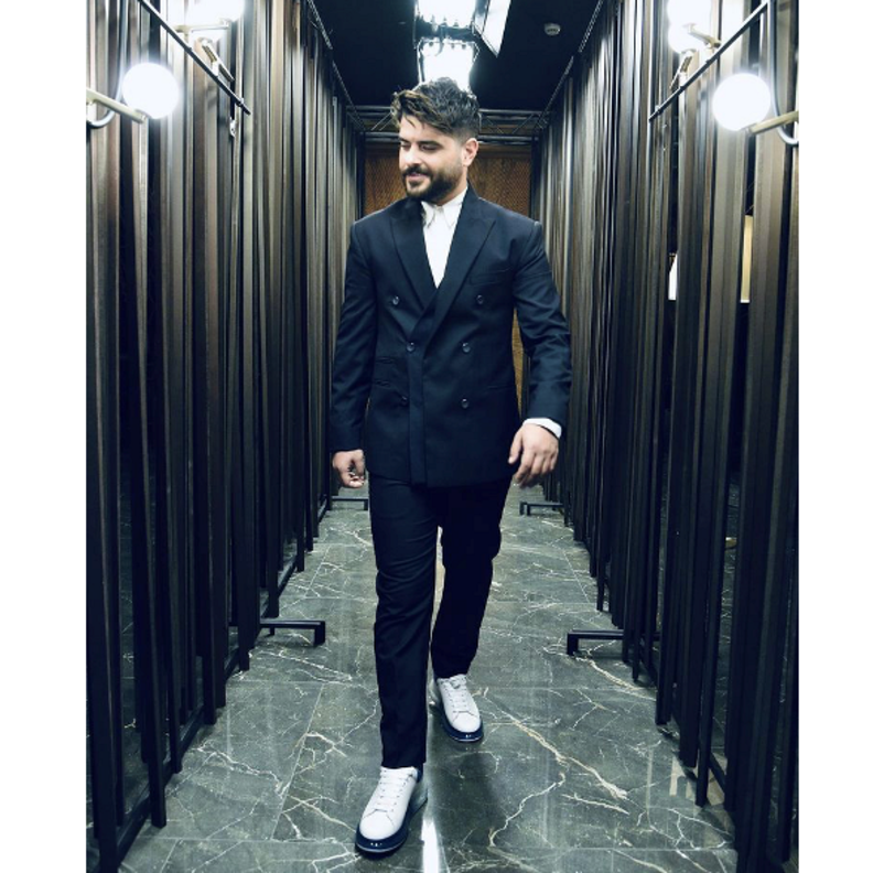بالبدلة السوداء مع الجاكيت بقصة الأزرار المزدوجة والتي نسّقها مع الحذاء الرياضي