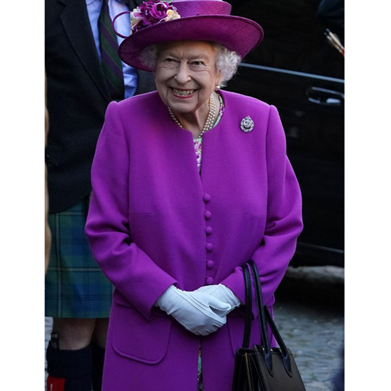 اطلالة الملكة اليزابيث بالمعطف البنفسجي والفستان المورد الصورة من AFP