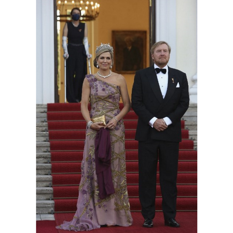 أكملت اللوك بالوشاح باللون البنفسجي الداكن والحقيبة الذهبية