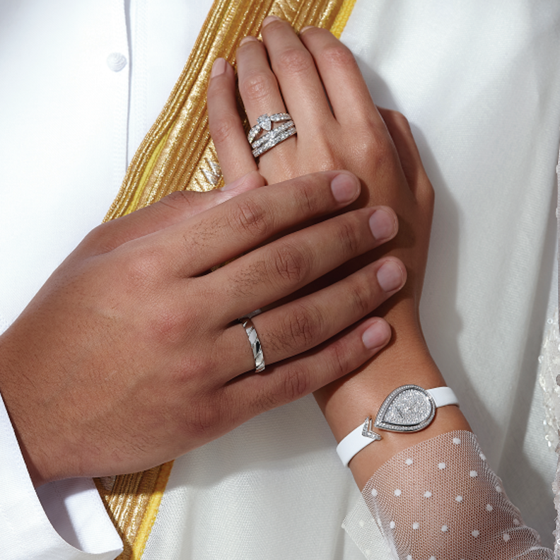 ساعة "جوزفين إيغريت" Joséphine Aigrette من الذهب الأبيض وبإطار مرصع بأحجار من الماس بالقطع اللمّاع، وميناء أبيض منقوش، وسوار من الساتان الأبيض. خاتما "جوزفين أوب برينتانيير" Joséphine Aube Printanière من البلاتين، مرصعان بالماس بالقطع اللمّاع، وقد رصع أحدهما بماسة على شكل إجاصة. على إصبع الرجل: خاتم "تورساد دو شوميه" Torsade de Chaumet من البلاتين. من "شوميه" Chaumet.