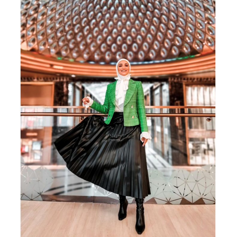 نسقت دلال الدوب البليزر مع التنورة البليسيه باللون الأسود والقميص الأبيض