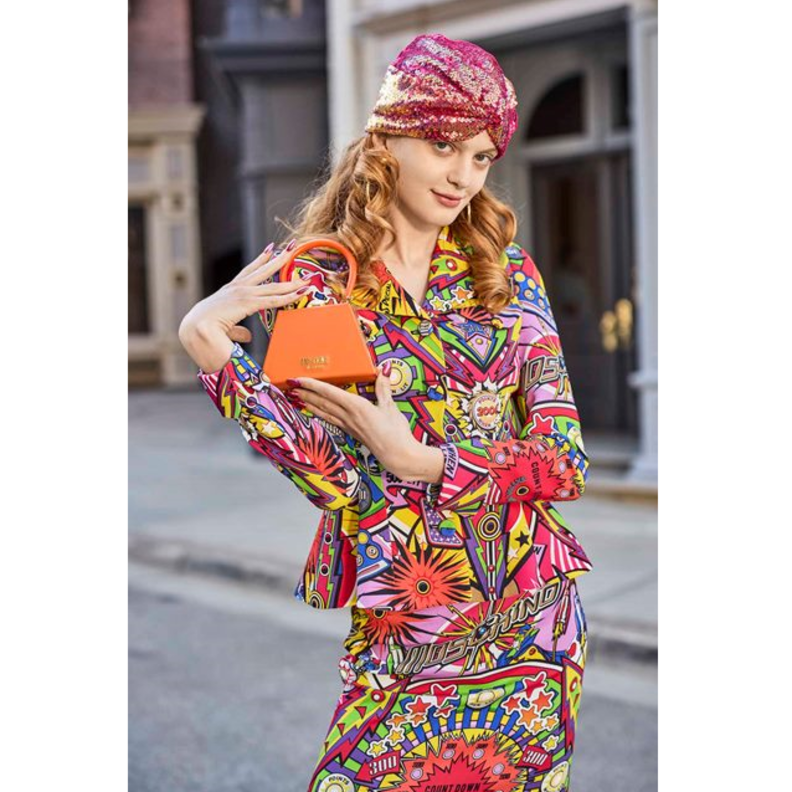 الحقيبة الميكرو باللون البرتقالي التي قدّمتها دار Moschino مع البدلة الملونة